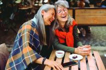 stockphotoprettyseniorasianwomanputsheadonlaughingfriendshoulderrestingtogetherattableinstreet2042101487.jpg