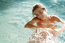 stockphotobeautifulyoungwomansmilinginaswimmingpoolunderthegoldensummerlight100270613.jpg