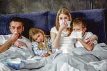 glavna--stockphotofamilyoffourhasaflueandlyingonbedtogether570823792.jpg