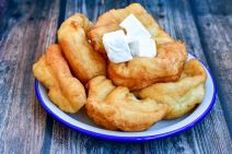stockphototraditionalbulgarianhomemadedeepfriedpattiescoveredwithsugarnrusticbackgroud2078862289.jpg