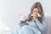stockphotoyoungwomanwithcoldblowingherrunnynosebrunettesneezinginatissueinthelivingroom1214604988.jpg