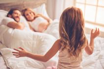 stockphotobeautifulpregnantwomanherhandsomehusbandandcutelittledaughteraresmilingwhilespending529090705.jpg