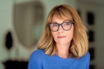 Žena sa naočarima za dioptriju pozira pred kamerom