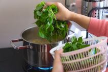 SPANAC  stock-photo-a-woman-is-blanching-or-cooking-spinach-in-a-pot-on-a-stove-she-is-holding-a-basket-of-spinach-in-2485989239.jpg