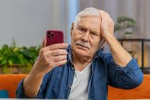 Stariji čovek gleda u telefon.jpg