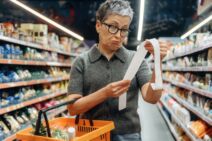 GLAVNA   stock-photo-older-woman-with-short-gray-hair-and-glasses-looks-at-her-shopping-receipt-while-holding-an-orange-2766455579.jpg