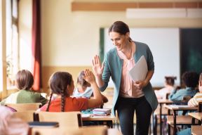 stockphotohappyelementaryschoolteachergivinghighfivetoherstudentduringclassintheclassroom2183363749.jpg