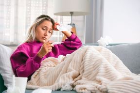 stockphotosicknessseasonalvirusproblemconceptwomanbeingsickhavingflulyingonsofalookingat1489936220.jpg