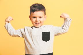 stockphotoimageoflittleboychildstandingisolatedoveryellowbackgroundlookingcamerashowingbiceps774844828.jpg