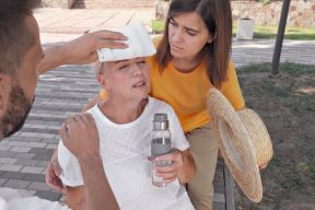 stockphotopeoplehelpingmaturewomanoncitystreetsufferingfromheatstroke2018612795.jpg