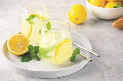 lemonana-stockphototraditionallemonadewithlemonmintandiceinaglasswithmetalstrawonagrayconcrete1929465701.jpg