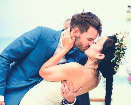 stockphotoyoungcouplekissingatweddingreception1106621789.jpg