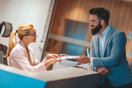 glavna--stockphotosecretarygivingdocumentstoabusinessmantheyareworkingtogetheronnewprojrct1324227062.jpg