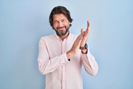 stockphotohandsomemiddleagemanwearingelegantshirtbackgroundclappingandapplaudinghappyandjoyful2169800031.jpg