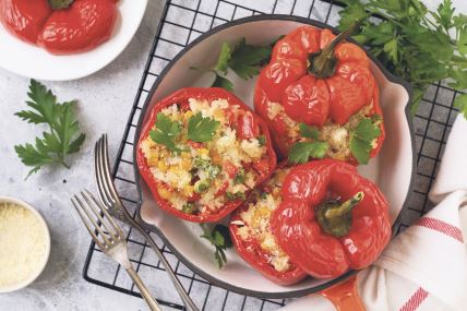 stockphotoredbellpeppersstuffedwithriceandvegetablesoncastironpanongrayconcretbackground1888793134.jpg