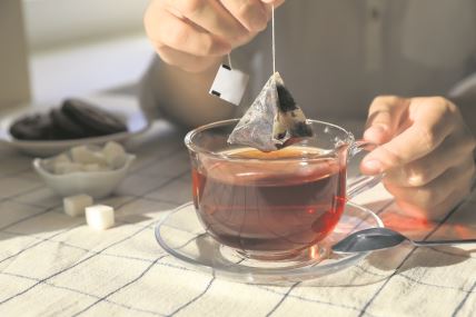 stockphotowomantakingteabagoutofcupattableindoorscloseup2232887661.jpg