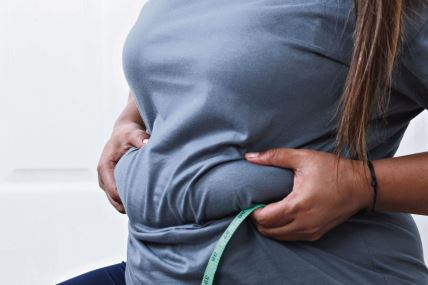 gojaznost--stockphotofatwomanfatbellychubbyobesewomanhandholdingexcessivebellyfatwithmeasuretapewoman2521101273.jpg