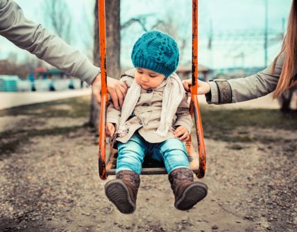 glavna--stockphotosadchildonaswinginbetweenherdivorcedparentsholdingherseparately132049541.jpg