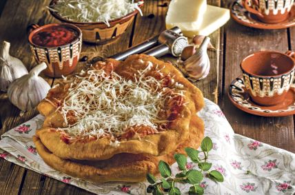 stockphototraditionallangosareoriginallyhungarianfriedpancakesmadefromyeastdoughtoppedwith377988070.jpg