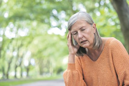 glavna--stockphotoelderlywomanoutdoorswithclosedeyesholdingheadshowingstressandheadachewearingorange2524377289.jpg