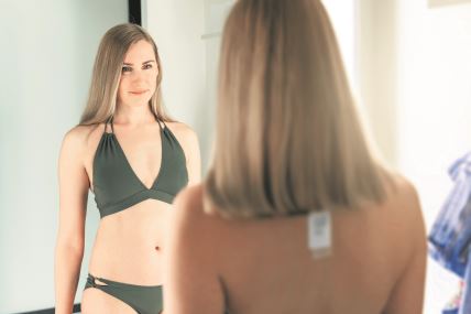 stock-photo-young-woman-trying-on-swimsuit-in-the-clothing-store-fitting-room-1665810739.jpg