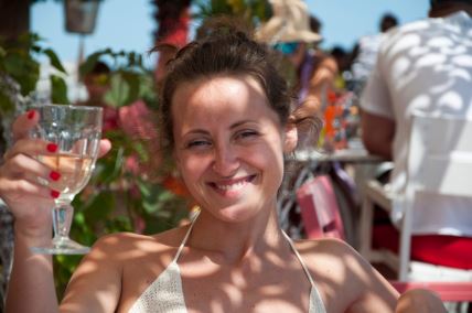 Devojka na plaži sa čašom u ruci