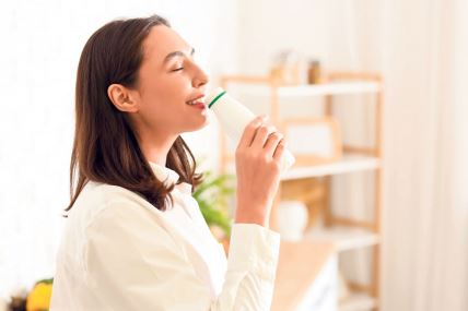 stock-photo-happy-young-woman-drinking-tasty-yoghurt-in-kitchen-2459669239.jpg