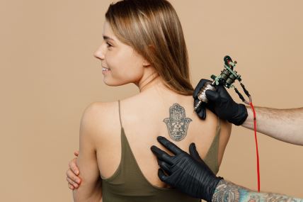 stock-photo-tattooer-master-artist-hold-machine-black-ink-in-jar-equipment-for-making-tattoo-art-on-back-view-2290547307.jpg