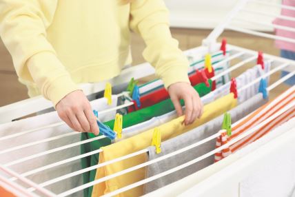 stock-photo-woman-hanging-fresh-clean-laundry-on-drying-rack-at-home-closeup-2627278215.jpg