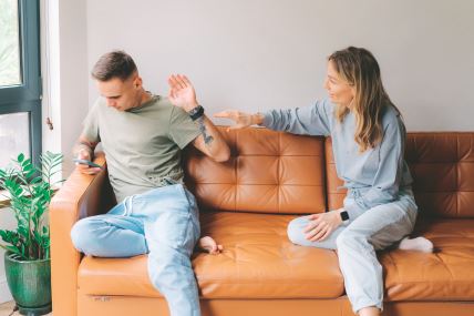 stock-photo-a-man-uses-a-mobile-phone-and-ignores-his-wife-who-wants-to-talk-about-problems-2142787627.jpg