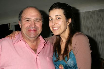 Stariji muškarac i mlađa žena poziraju pred kamerom