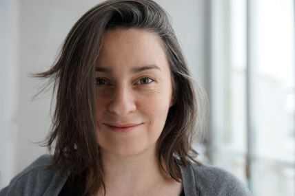 Portret devojke koja nasmešena gleda u kameru