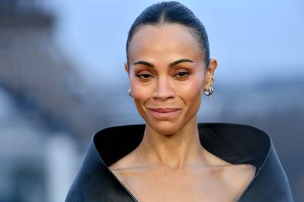 Zoi Saldana na crvenom tepihu u krupnom kadru gleda u kameru