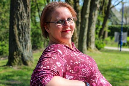 Žena u pink majici sedi u parku