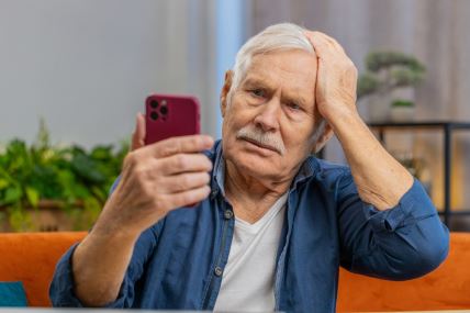 Stariji čovek gleda u telefon.jpg