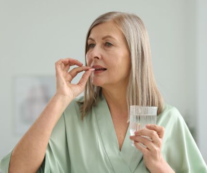 GLAVNA  stock-photo-woman-with-glass-of-water-taking-collagen-pill-at-home-2610292297.jpg