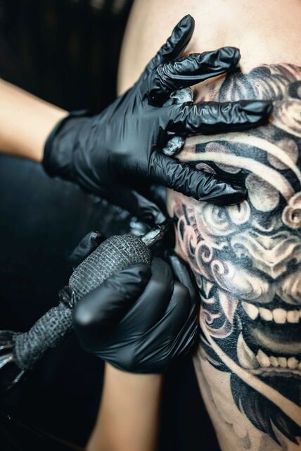 GLAVNA stock-photo-professional-woman-artist-making-stylish-black-tattoo-of-japanese-demon-mask-on-man-hand-with-2502869061.jpg