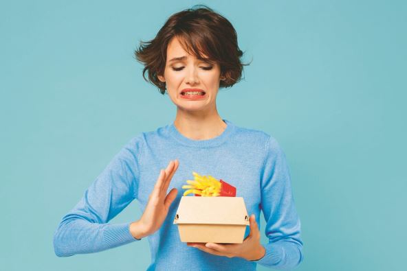 brza-hrana----stockphotoyoungwomanwearsweaterholdaboxwithfastfoodfrenchfriespotatoburgershowstoppalmgesture2082743908.jpg