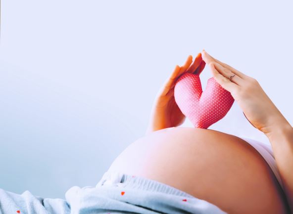 seks-u-trudnoci--stockphotopregnantwomanholdsinpalmssymbolinheartshapelovingmomwaitingofababyconceptof1889358724.jpg