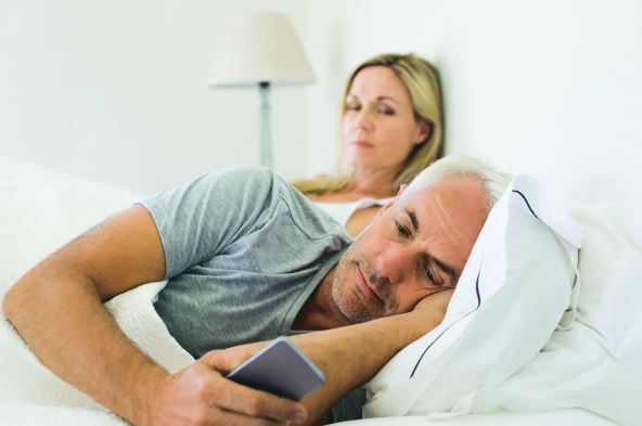 uz-prvu-glosu-stockphotojealouswomanspyingherhusbandmobilephonewhileheisreadingamessageseniorcoupleinbed432830212.jpg