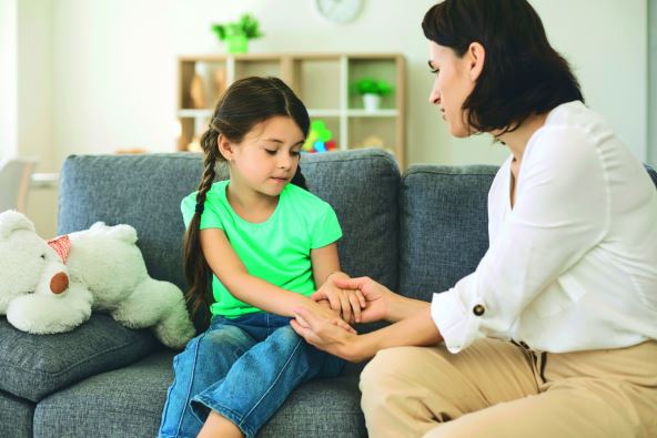 slika-za-glosu-stockphotoyoungmothersittingonsofawithdaughterholdingherhandsandtalkingtoherseriouslyathome1815086069.jpg