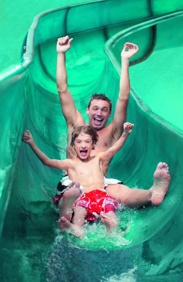stockphotoportraitoffatherandsonwitharmsoutstretchedonwaterslide146681711.jpg