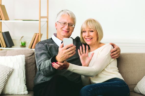 stockphotohappyseniorcouplemakingvideocallonphoneandwavingtocaller1408071635-c.jpg