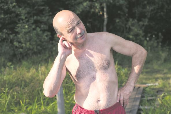 bolne-usi-stockphotomatureeuropeanmanwithmustachetryingtopullwateroutofearafterswimminginlakeorriver1143848639.jpg
