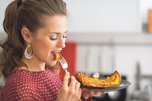 antr-stockphotoportraitofyoungwomaneatingbakedpumpkininkitchen249402982.jpg
