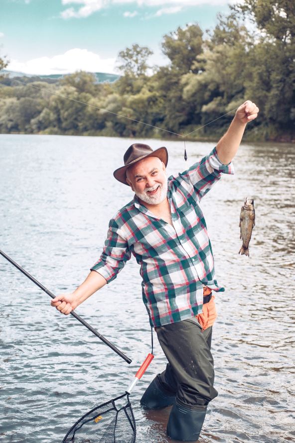 stockphotohappyoldfishermancaughtatroutfishportraitofcheerfulsmilingseniormanfishing2189322991.jpg