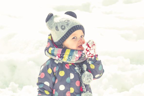 stockphotoadorablebabyeatcoldsnowfrommittensinsunnywinterpark575349562.jpg