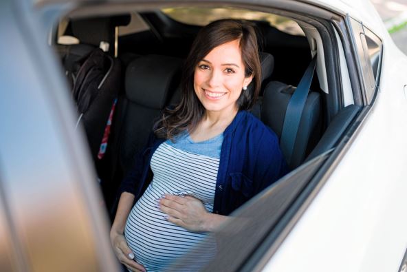 stockphotoportraitofapregnantwomansmilingwiththecarwindowsdowncheerfulpregnantwomanonherway1898758675.jpg