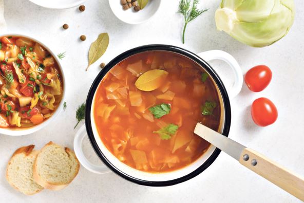 stockphotocabbagesoupincookingpotoverwhitestonebackgroundtopviewflatlay2149769495.jpg