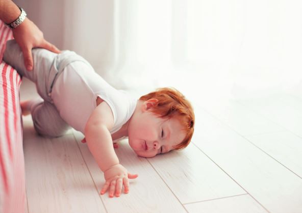 antrfile---stockphotopoorlittletoddlerbabyfelldownfromthebedwhilecrawlingonitdadmissedtocatchhim594031835.jpg